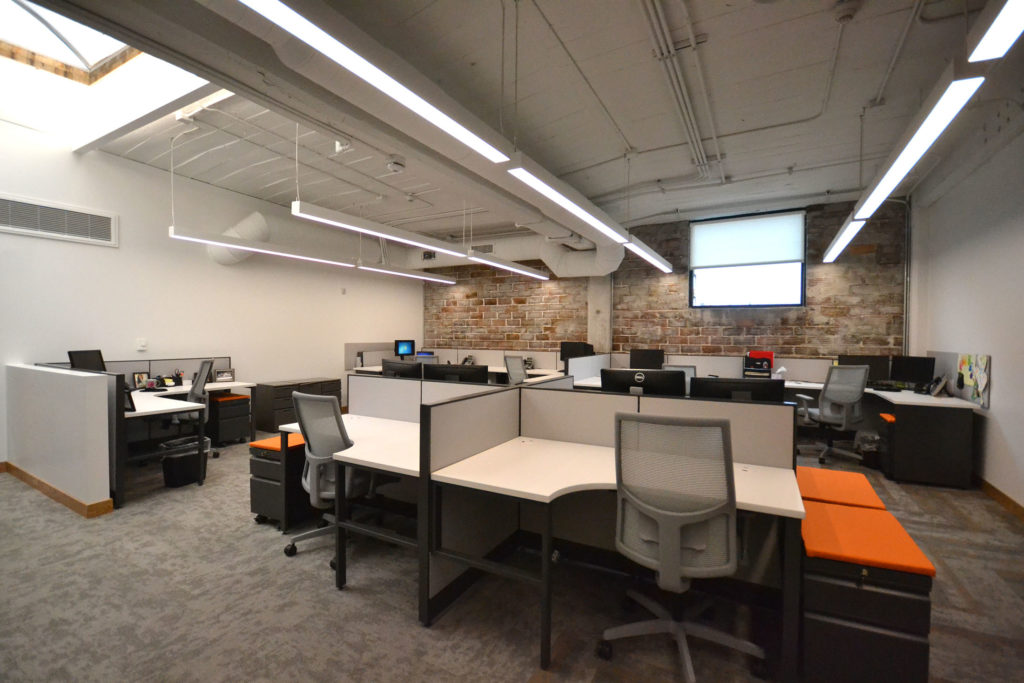 Workstations in an open office with desk partitions separating spaces.