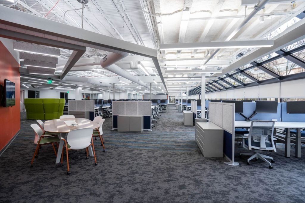 An open office environment with a meeting area near a group of workstations.