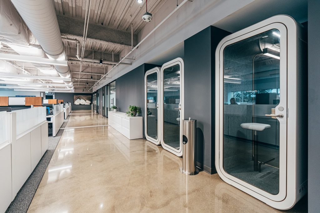 Privacy pods line the hallway in an office setting.
