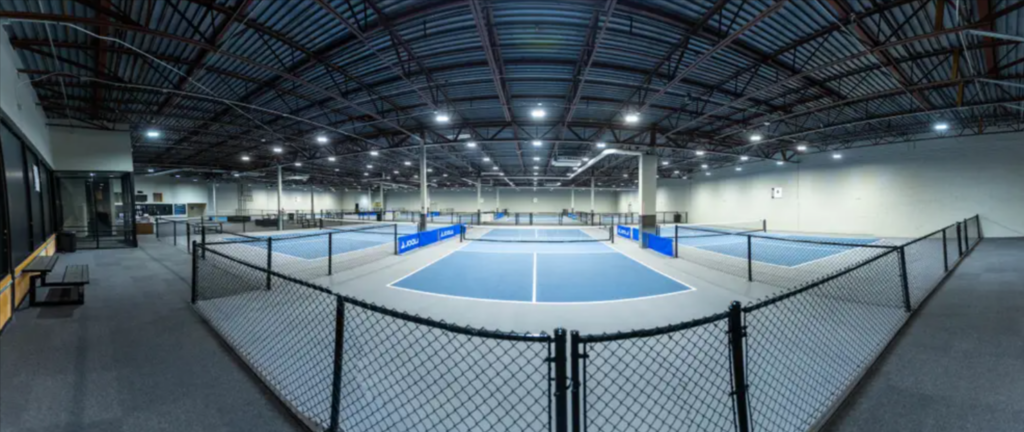 Empty pickleball courts inside a converted Staples store location.