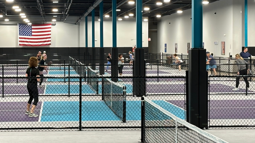 People playing pickleball on a court in a former Burlington store location.
