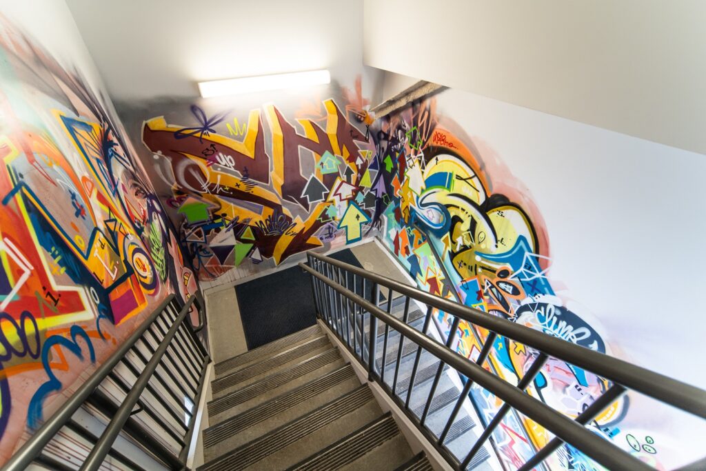Office stairwell with graffiti art on walls. 